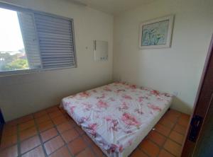 a bedroom with a bed with pink flowers on it at AP de Itapirubá in Imbituba