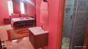 a bathroom with a sink and a bedroom with a bed at Maison Touria in Ouzoud
