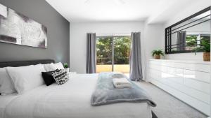 a bedroom with a large bed and a window at Marine Adventures in Callala Bay