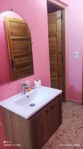 a bathroom with a sink and a pink wall at Maison Touria in Ouzoud