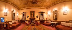 a living room with couches and chairs and a ceiling at The Red House in Ooty