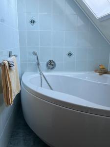 une baignoire blanche dans une salle de bains avec fenêtre dans l'établissement Ferienwohnung Ruppbergblick, à Zella-Mehlis