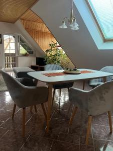 une salle à manger avec une table et des chaises blanches dans l'établissement Ferienwohnung Ruppbergblick, à Zella-Mehlis
