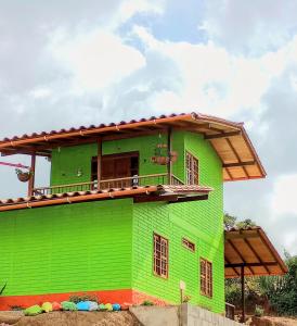 a green house with a balcony on top of it at Panorama d Colores 2 in Jardin