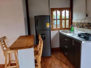 a kitchen with a black refrigerator and a wooden table at Panorama d Colores 2 in Jardin