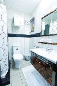 a bathroom with a toilet and a sink and a mirror at Easy Inn Hotel Suites in Amman