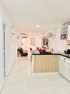a kitchen and living room with white floors and a counter at Internacional Hermoso y Céntrico in Santa Marta