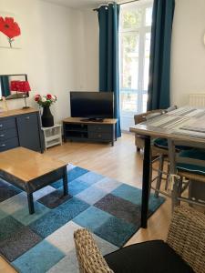 un soggiorno con un tavolo e una TV di Appt lumineux, Thermes et Montagne a La Bourboule