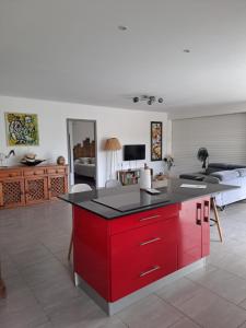 a kitchen with a red island in a living room at Villa Jasmin in Sainte-Rose
