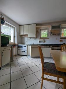 een keuken met witte kasten en een tafel met een stoel bij Casa Lagoraiview in Carano