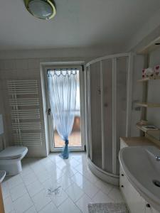 een badkamer met een wastafel en een toilet en een raam bij Casa Lagoraiview in Carano +32 foto's