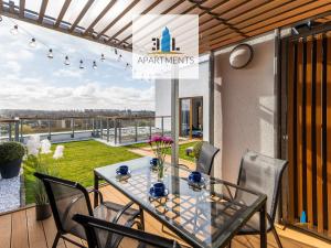 stół i krzesła na balkonie z widokiem w obiekcie 3L Apartments Olympic Park w Kołobrzegu