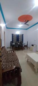 a room with a bed and chairs and a ceiling at Marigold Homestay in coorg in Madikeri