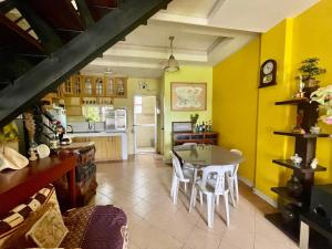 a kitchen with yellow walls and a table and chairs at Whiteplace Transient House in Rioeng