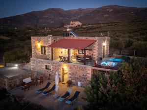 a stone building with chairs and a swimming pool at Blue Pearl Villa in AmigdhalokeFálion