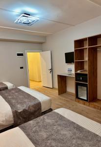 a hotel room with two beds and a flat screen tv at Skymoon Istanbul Airport Hotel in Arnavutköy