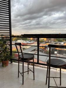 a balcony with two chairs and a view of a city at Studio for Tourism or Business Trip in Corrientes +7 photos