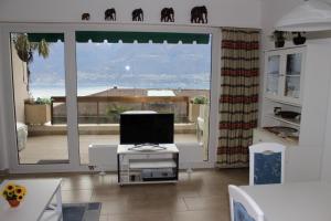 a living room with a large window with a view of the ocean at Ferienwohnung C04 in Orselina