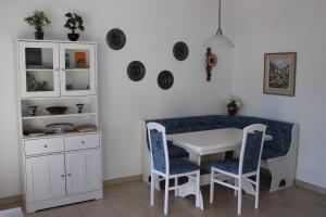 a dining room with a white table and blue chairs at Ferienwohnung C04 in Orselina +11 photos