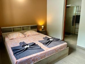 a bedroom with a bed with black bows on it at Grande villa moderne, calme, piscine & jardin in Le Gosier +32 photos