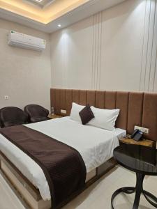 Postel nebo postele na pokoji v ubytování Shri Sangam Hotel
