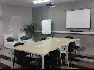 a meeting room with a table and chairs and a screen at Luxury Privat Villa Merellä in Kalajoki