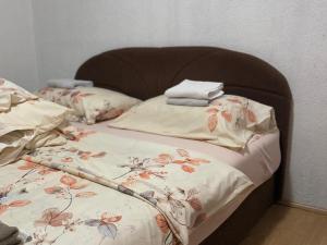 ein Bett mit einer Blumendecke und Kissen darauf in der Unterkunft Apartman Ana in Kupres
