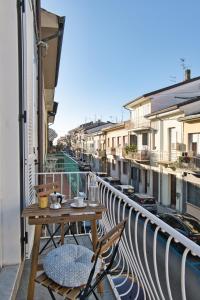 un balcone con tavolo e sedie su un balcone di Via Puccini 217 a Viareggio