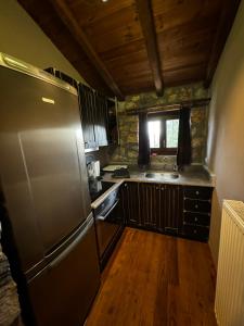 a kitchen with a stainless steel refrigerator and wooden floors at Forest House in Palaios Agios Athanasios +12 photos