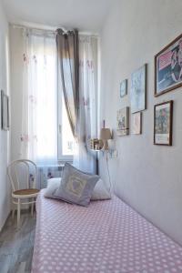 una camera da letto con un letto con una coperta rosa e una finestra di Via Puccini 217 a Viareggio