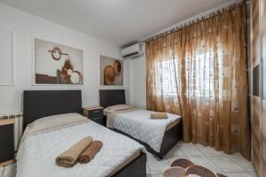 a bedroom with two beds with towels on them at Beachfront Apartments Durres in Durrës +93 photos
