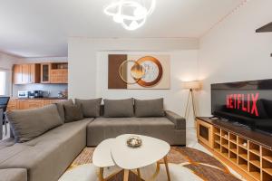 a living room with a couch and a tv at Beachfront Apartments Durres in Durrës