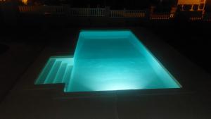 ein im Dunkeln beleuchteter Swimmingpool in der Unterkunft Casa Maria in São Domingos de Rana