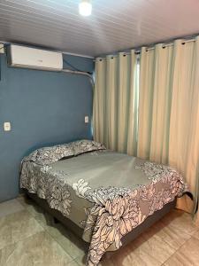 a small bed in a small room with curtains at Casa familiar rua 13 maio número 1639 in Rosário do Sul +12 photos