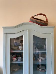 a basket on top of a cabinet with dishes at Ergzotic Apartments & Room in Sombor
