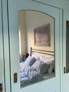 a mirror reflection of a bed in a bedroom at Ergzotic Apartments & Room in Sombor