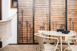 einen Tisch und Stühle in einem Zimmer mit einer Holzwand in der Unterkunft BnB Homes Modern Cozy Townhouse with 2 bedrooms and patio in the Old Town in Portimão + 37 Fotos