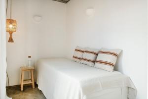 ein weißes Schlafzimmer mit einem Bett und einem Tisch in der Unterkunft BnB Homes Modern Cozy Townhouse with 2 bedrooms and patio in the Old Town in Portimão