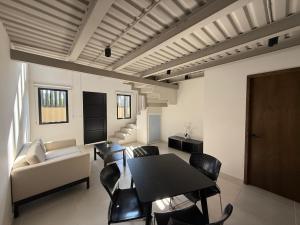 a living room with a table and chairs and a couch at Homa Lofts in Colima