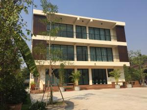 a building with a lot of windows and plants at Ma Room Place Sukhothai Resort in Sukhothai