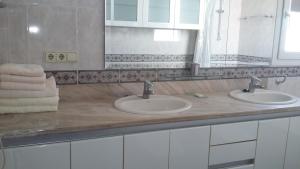 a bathroom with two sinks and a mirror and towels at Al Centre Del Port in Cambrils +34 photos
