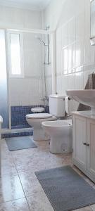 サン・ペドロ・デル・ピナタルにあるVILLA FLAMINGO San Pedro del Pinatar Beach Houseの白いバスルーム(トイレ2つ、シンク付)