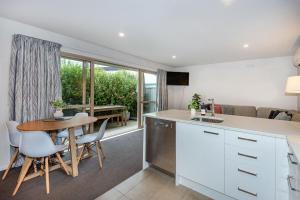 a kitchen and living room with a table and chairs at Urban Oasis Central Christchurch - parking in Christchurch
