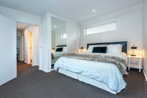 a bedroom with a large bed and a mirror at Urban Oasis Central Christchurch - parking in Christchurch
