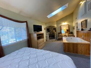 a bedroom with a bed and a tub and a television at Pine Knot Guest Ranch in Big Bear Lake