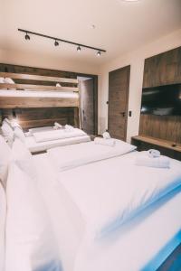 a group of four white beds in a room at LIVALPIN Comfort in Garmisch-Partenkirchen +42 photos