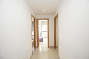 un corridoio con pareti bianche e pavimento piastrellato bianco di Apartamento Riu Fluvià Girona a Girona