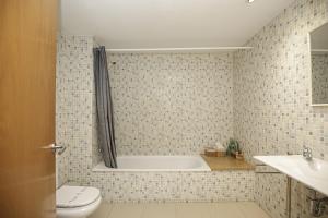 un bagno con vasca, WC e lavandino di Apartamento Riu Fluvià Girona a Girona