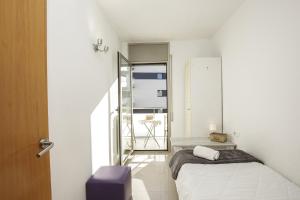una piccola stanza con un letto e uno specchio di Apartamento Riu Fluvià Girona a Girona