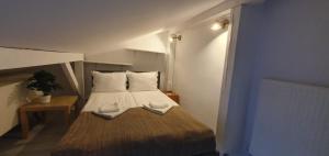 a small bedroom with a bed with white sheets and pillows at Villa 31 in Sopot